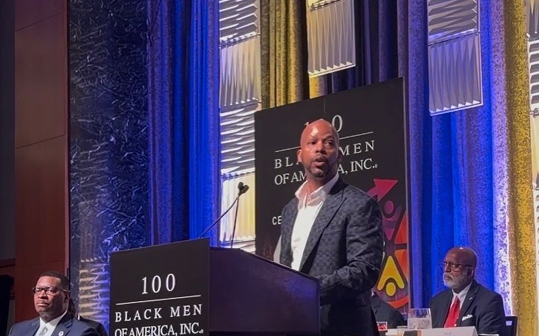 Quentin Fears speaking on stage at the 100 Black Men of America national conference
